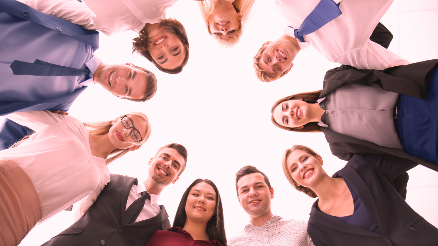 Corporate & Business Workshops Team standing in a circle looking down at the camera